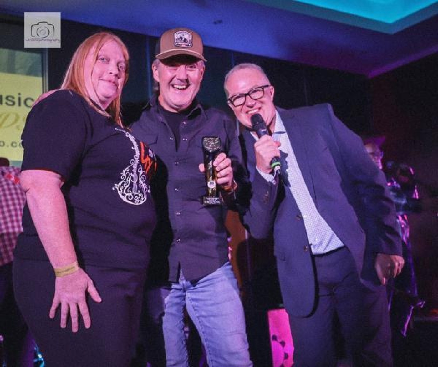 Dan Jones on stage being presented with the UKCountryRadio.com Song Award trophy